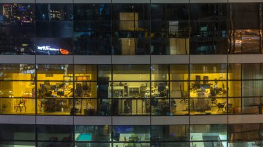Çok öykülü modern cam ve metal ofis kadar ışık gece timelapse Bina içinde parlayan pencere eşiği. İşçiler bir kutu içinde. Geceleri aydınlatılan ofis binası. Aşağı kaydır