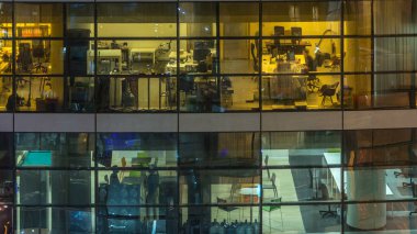 Çok öykülü modern cam ve metal ofis kadar ışık gece timelapse Bina içinde parlayan pencere eşiği. İşçiler bir kutu içinde. Geceleri aydınlatılan ofis binası. Sağa çevir