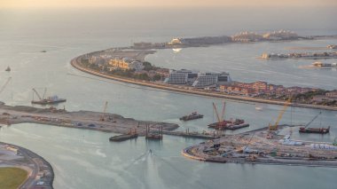 Palm Jumeirah Adası timelapse hava görünümünü. Villa, otel ve yat ile üstten görünüm akşam. Yeni cruise terminal inşaat süreci