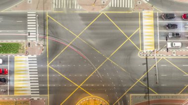 Bir büyük şehir gece timelapse bir yol kavşak hava üstten görünüm. Arabalar ve tramvay hattı ile UAE Dubai Yat Limanı bölgesinin kentsel peyzaj.