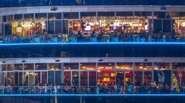 Dubai Yat Limanı ilçe gece timelapse kalbinde her katta farklı Restoranları ile dairesel yapının. Görünümü farklı düzeylerde, ışıklı windows oturan insanlar ile yakın