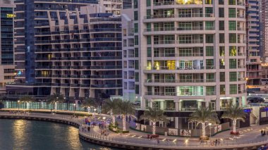 Geçen tekneler ve avuç içi gün gece ile promenade ile lüks Dubai Yat Limanı kanal timelapse geçiş, yukarıdan bakışta akşam güneş battıktan sonra Top. Dubai, Birleşik Arap Emirlikleri