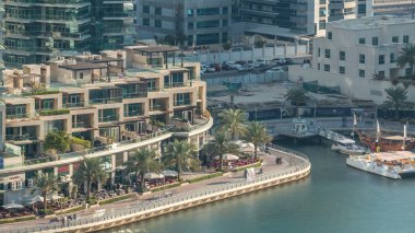 Lüks Dubai Yat Limanı kanal geçen tekneler ile ve avuç içi timelapse ile promenade, üst görüntülemek üzerinden yukarıda akşam gün batımına. Dubai, Birleşik Arap Emirlikleri