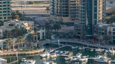 Lüks Dubai Yat Limanı kanal geçen tekneler ile ve avuç içi timelapse ile promenade, üst görüntülemek üzerinden yukarıda akşam gün batımına. Dubai, Birleşik Arap Emirlikleri