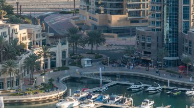 Lüks Dubai Yat Limanı kanal geçen tekneler ile ve avuç içi timelapse ile promenade, üst görüntülemek üzerinden yukarıda akşam gün batımına. Dubai, Birleşik Arap Emirlikleri