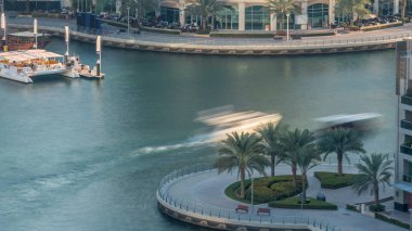 Lüks Dubai Yat Limanı kanal geçen tekneler ile ve avuç içi timelapse ile promenade, üst görüntülemek üzerinden yukarıda akşam gün batımına. Dubai, Birleşik Arap Emirlikleri