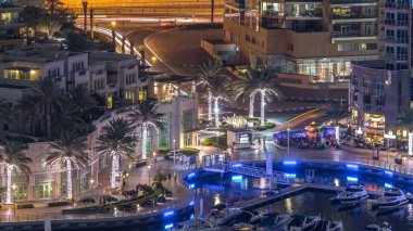Lüks Dubai Yat Limanı kanal geçen tekneler ile ve mesire Restoran gece timelapse ile üst görüntülemek üzerinden yukarıda ile ışıklandırılmış gökdelenler. Dubai, Birleşik Arap Emirlikleri