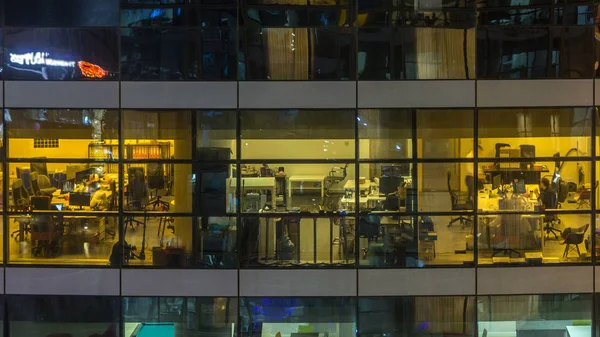 Çok öykülü modern cam ve metal ofis kadar ışık gece timelapse Bina içinde parlayan pencere eşiği. İşçiler bir kutu içinde. Geceleri aydınlatılan ofis binası. Yukarı kaydır