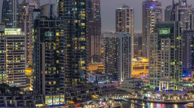 Geçen tekneler ve mesire Restoran gün gece ile lüks Dubai Yat Limanı kanal timelapse geçiş, ışıklandırılmış gökdelenler ile yukarıdan görünüm güneş battıktan sonra Top. Dubai, Birleşik Arap Emirlikleri