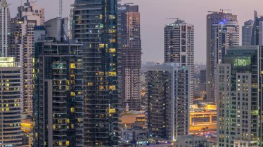 Geçen tekneler ve mesire Restoran gün gece ile lüks Dubai Yat Limanı kanal timelapse geçiş, ışıklandırılmış gökdelenler ile yukarıdan görünüm güneş battıktan sonra Top. Dubai, Birleşik Arap Emirlikleri