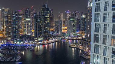Lüks Dubai Yat Limanı kanal geçen tekneler ile ve mesire Restoran gece timelapse ile üst görüntülemek üzerinden yukarıda ile ışıklandırılmış gökdelenler. Dubai, Birleşik Arap Emirlikleri