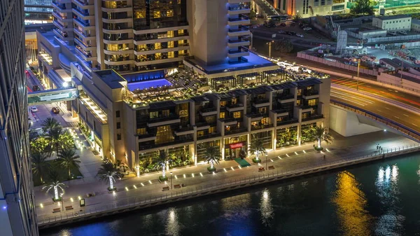 Lüks Dubai Yat Limanı kanal trafiği olan ve mesire Restoran gece timelapse ile üst görüntülemek üzerinden yukarıda ile ışıklandırılmış gökdelenler. Dubai, Birleşik Arap Emirlikleri