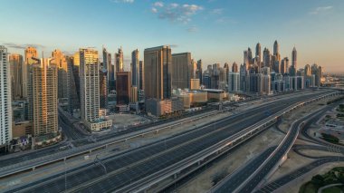 Dubai Yat Limanı gökdelenler hava üstten görünüm Jlt üzerinden sabah Dubai timelapse, BAE güneş doğarken sırasında. Modern kule uzun gölgeler aşağıya taşınması ve Şeyh zayed yolu üzerinde trafik ile.