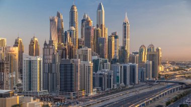 Dubai Yat Limanı gökdelenler hava üstten görünüm Jlt üzerinden sabah Dubai timelapse, BAE güneş doğarken sırasında. Modern kule uzun gölgeler aşağıya taşınması ve Şeyh zayed yolu üzerinde trafik ile.