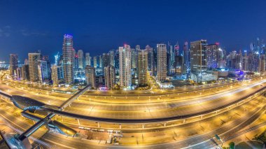 Dubai Yat Limanı gökdelenler hava üstten görünüm güneş doğmadan önce Jlt gelen Dubai gece gün timelapse, Birleşik Arap Emirlikleri için. Işıklı modern kuleleri ve Şeyh zayed yolu üzerinde trafik.