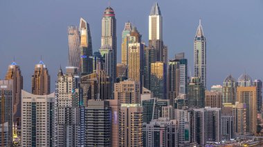 Dubai Yat Limanı kuleleri panorama gün gece geçiş timelapse için dönüş ışıkları. Gökdelenler, BAE gece aydınlatma. Hava Jlt görünümünden