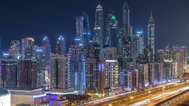 Dubai Yat Limanı timelapse fantastik çatı manzarası. Büyük bir şehrin gece, Birleşik Arap Emirlikleri tarafından aydınlatılmış en yüksek gökdelenler. Hava Jlt görünümünden