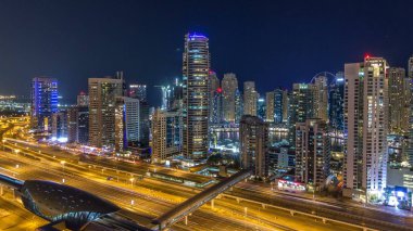 Dubai Yat Limanı timelapse fantastik çatı manzarası. Işıklandırılmış gökdelenler büyük bir şehrin gece, Birleşik Arap Emirlikleri. Hava Jlt görünümünden