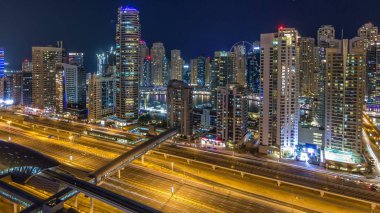 Dubai Yat Limanı timelapse fantastik çatı manzarası. Işıklandırılmış gökdelenler büyük bir şehrin gece, Birleşik Arap Emirlikleri. Hava Jlt görünümünden