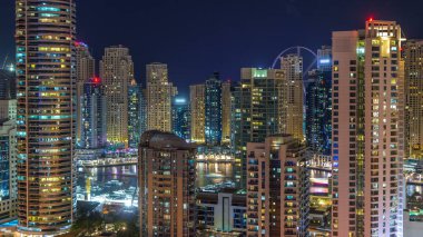Dubai Marina deniz araçları timelapse ile fantastik çatı manzarası. Işıklandırılmış gökdelenler büyük bir şehrin gece, Birleşik Arap Emirlikleri. Hava Jlt görünümünden