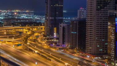 Dubai Yat Limanı gökdelenler hava üstten görünüm güneş doğmadan önce Jlt gelen Dubai gece gün timelapse, Birleşik Arap Emirlikleri için. Işıklı modern kuleleri ve kavşak ile Şeyh zayed yolu üzerinde trafik