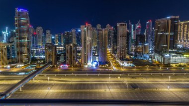 Dubai Yat Limanı timelapse tüm gece boyunca muhteşem çatı manzarası. Işıklandırılmış gökdelenler, Birleşik Arap Emirlikleri, dönüm büyük bir şehir. Hava Jlt görünümünden