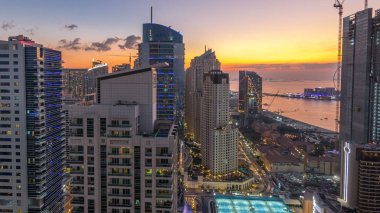 JBR ve Dubai marina gece geçiş timelapse günbatımı hava gün sonra. Modern kuleleri ve gökdelenler, yat ve tekne Körfezi üzerinde yüzen