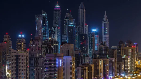 Fantastic rooftop skyline of Dubai marina timelapse during all night. Illuminated skyscrapers of a big city turning off, United Arab Emirates. Aerial view from JLT