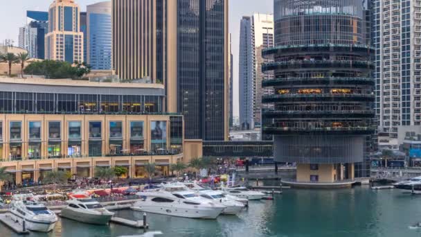 Veta aérea de Dubai Marina con centro comercial, restaurantes, torres y yates día a noche timelapse, Emiratos Árabes Unidos . — Vídeo de stock