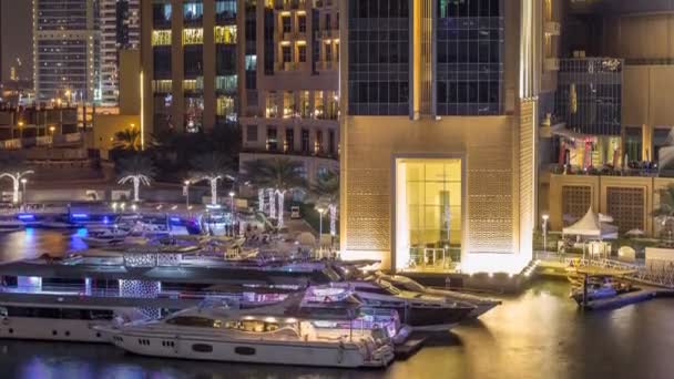 Luchtfoto toegangscode van Dubai Marina met shoping mall, restaurants, torens en jachten nacht timelapse, Verenigde Arabische Emiraten. — Stockvideo