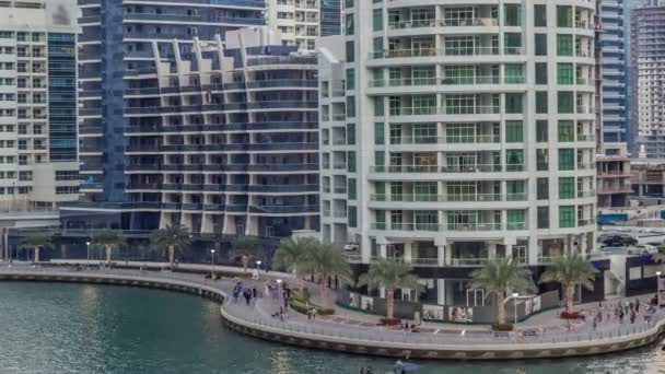 Luxury Dubai Marina canal com barcos que passam e calçadão dia a noite timelapse, Dubai, Emirados Árabes Unidos — Vídeo de Stock