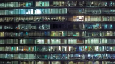 Cam duvarlar ve pencereler timelapse ile çok sayıda ofis ile cam ofis binasında çalışma gecesi