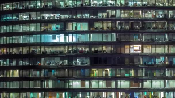 Arbets kväll i glas kontorsbyggnad med många kontor med glasväggar och fönster Timelapse — Stockvideo