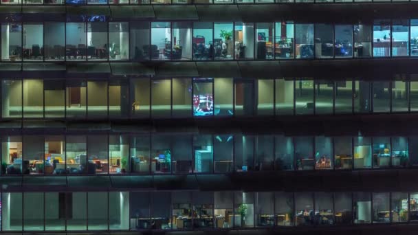 Noche de trabajo en edificio de oficinas de vidrio con numerosas oficinas con paredes de vidrio y ventanas timelapse — Vídeos de Stock