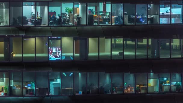 Soirée de travail dans un immeuble de bureaux en verre avec de nombreux bureaux avec des murs en verre et des fenêtres timelapse — Video