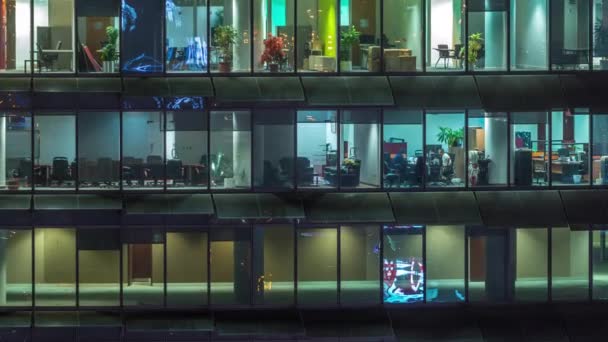 Serata di lavoro in edificio per uffici in vetro con numerosi uffici con pareti in vetro e timelapse finestre — Video Stock