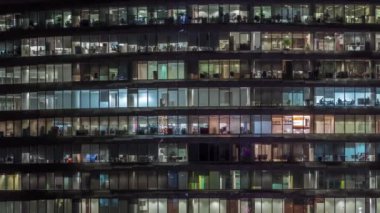 Cam duvarlar ve pencereler timelapse ile çok sayıda ofis ile cam ofis binasında çalışma gecesi