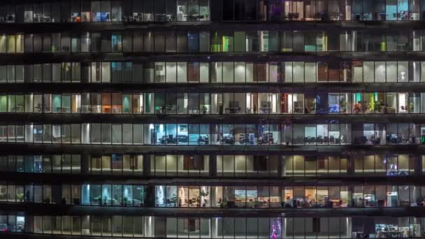 Робочий вечір у скляній офісній будівлі з численними офісами зі скляними стінами та вікнами — стокове відео