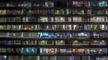 Cam duvarlar ve pencereler timelapse ile çok sayıda ofis ile cam ofis binasında çalışma gecesi