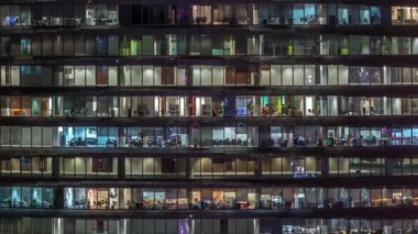 Cam duvarlar ve pencereler timelapse ile çok sayıda ofis ile cam ofis binasında çalışma gecesi