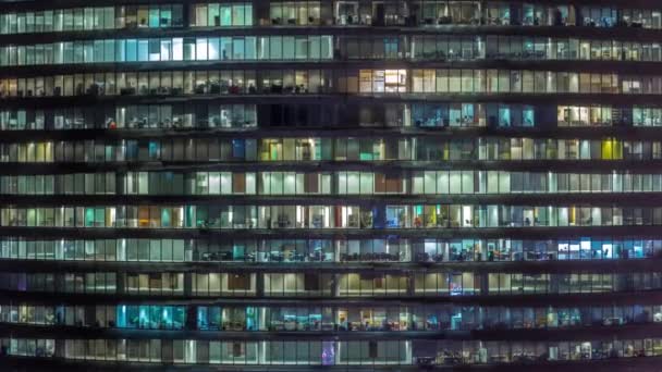 Noite de trabalho no prédio de escritórios de vidro com vários escritórios com paredes de vidro e janelas timelapse — Vídeo de Stock