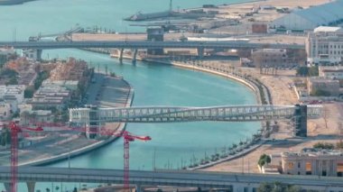 Downtown gökdelenler çatıdan gün batımı hava timelapse sırasında yaya köprüsü ile Dubai su kanalı