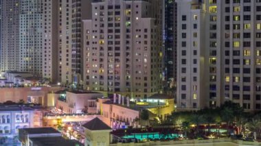 Dubai, Bae'de gökdelenler gece saatlerinde Jbr'de yürüyen plaj ve turistlerin havadan görünümü