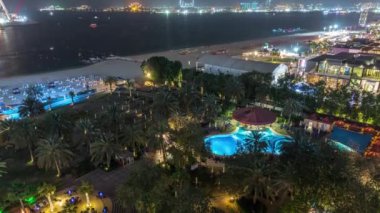 Dubai, Bae'de gökdelenler gece saatlerinde Jbr'de yürüyen plaj ve turistlerin havadan görünümü