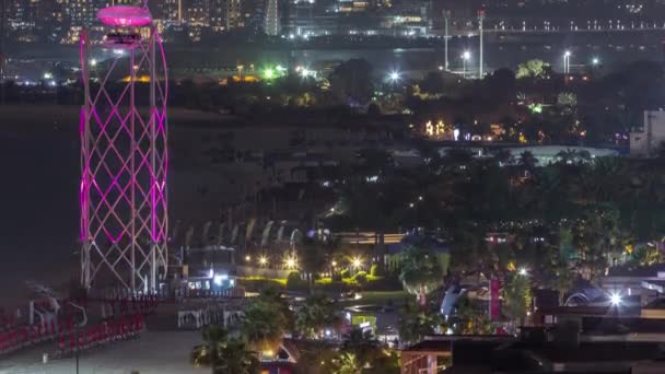 Vue aérienne de la plage et des touristes marchant dans le JBR avec des gratte-ciel timelapse nocturne à Dubaï, Émirats Arabes Unis — Video