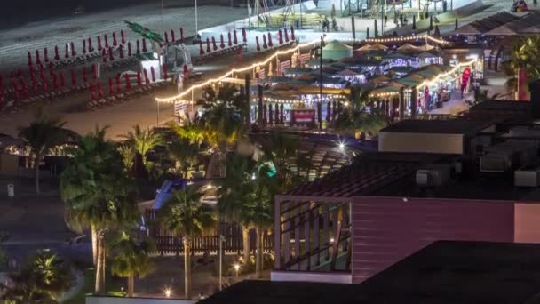 Dubai, Bae'de gökdelenler gece saatlerinde Jbr'de yürüyen plaj ve turistlerin havadan görünümü — Stok video