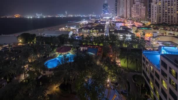 Dubai, Bae'de gökdelenler gece saatlerinde Jbr'de yürüyen plaj ve turistlerin havadan görünümü — Stok video