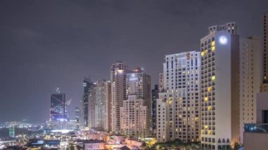 Dubai, Bae'de gökdelenler gece saatlerinde Jbr'de yürüyen plaj ve turistlerin havadan görünümü