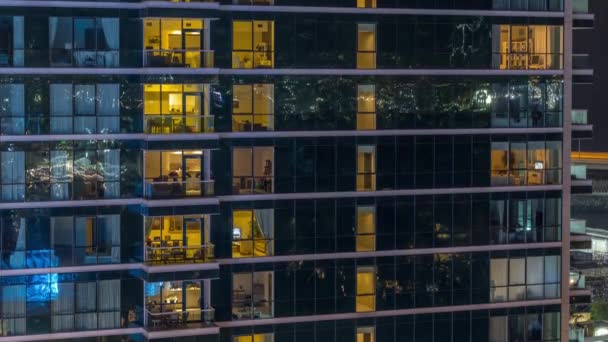 Сяючі вікна квартири вночі в скляному хмарочосі — стокове відео