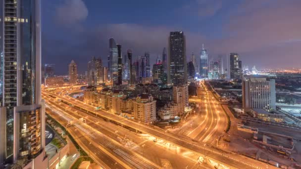 Skyline kilátás az épületek Sheikh Zayed Road és a DIFC éjjel a nap TimeLapse Dubai, UAE. — Stock videók